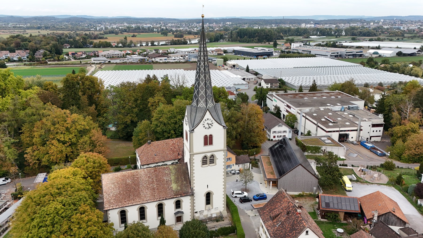 Luftaufnahme der evangelischen Kirche Tägerwilen mit Kirchturm und umliegender Landschaft